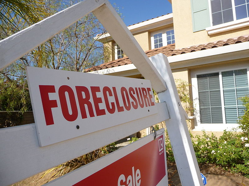Foreclosure sign in front of house. 