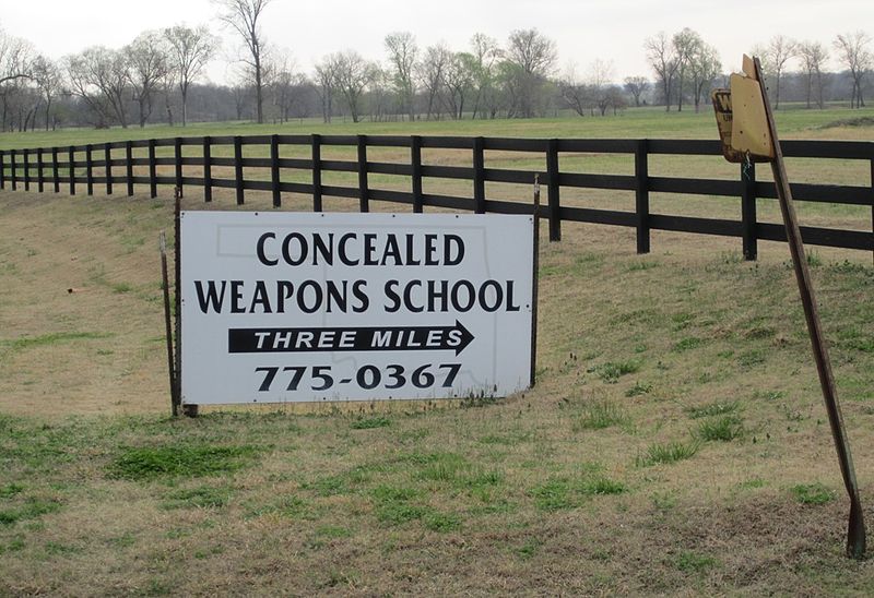 A sign reading: concealed weapons school